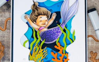 Die cut tunnelscape card featuring Spellbinders Paper Arts Underwater Tunnel die set and a Copic marker coloured mermaid digital stamp from Sweet November Stamps.