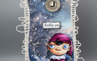 Wintry Christmas tag featuring AALL & Create Janet Klein Elf Made stamp set and Intricatag die set, along with other products!
